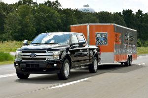 black 2018 Ford F-150 towing a trailer that says built Ford tough