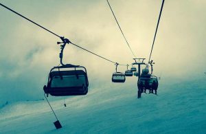 skiers riding a ski lift