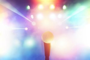 first person view of a microphone with bright colorful lights in the background