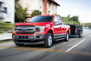 red 2018 Ford F-150 Diesel towing a trailer down the road