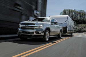 white 2018 Ford F-150 Diesel towing an RV