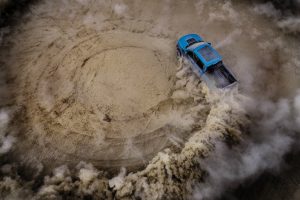 aerial view of a blue 2019 Ford F-150 Raptor doing off-road donuts