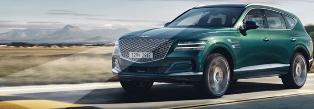 Green 2021 Genesis GV80 with Advanced Safety Systems on Desert Highway