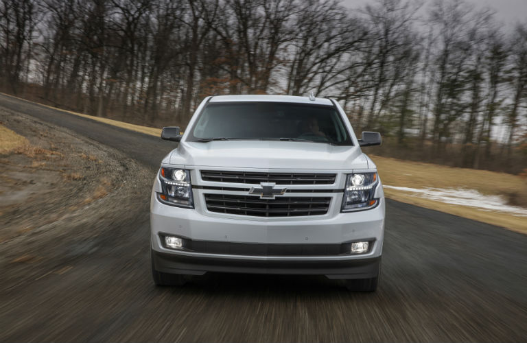 Front grille of Chevrolet Tahoe driving down wintry road on overcast day
