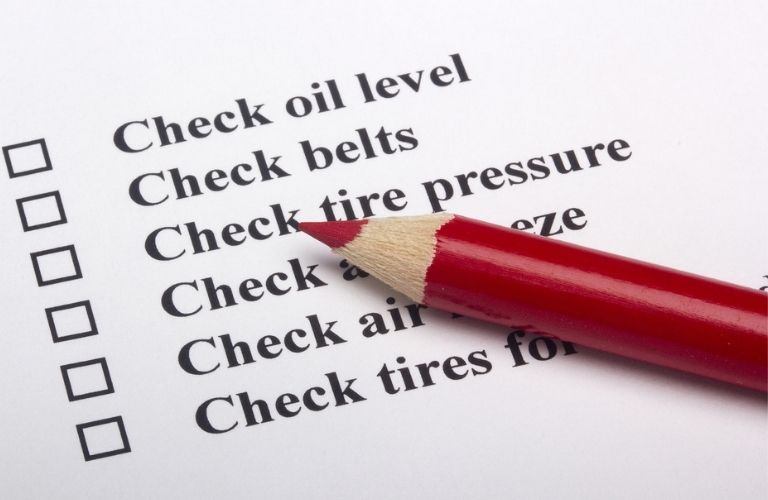 a vehicle inspection checklist with a red pencil