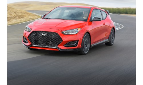 2019 Hyundai Veloster N exterior shot with red paint color driving around a curving country road