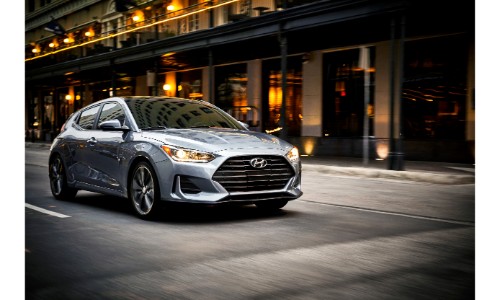 2019 Hyundai Veloster exterior shot with gray silver paint color driving through the city