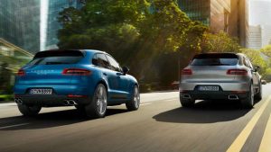 two 2018 Porsche Macan driving on a city road