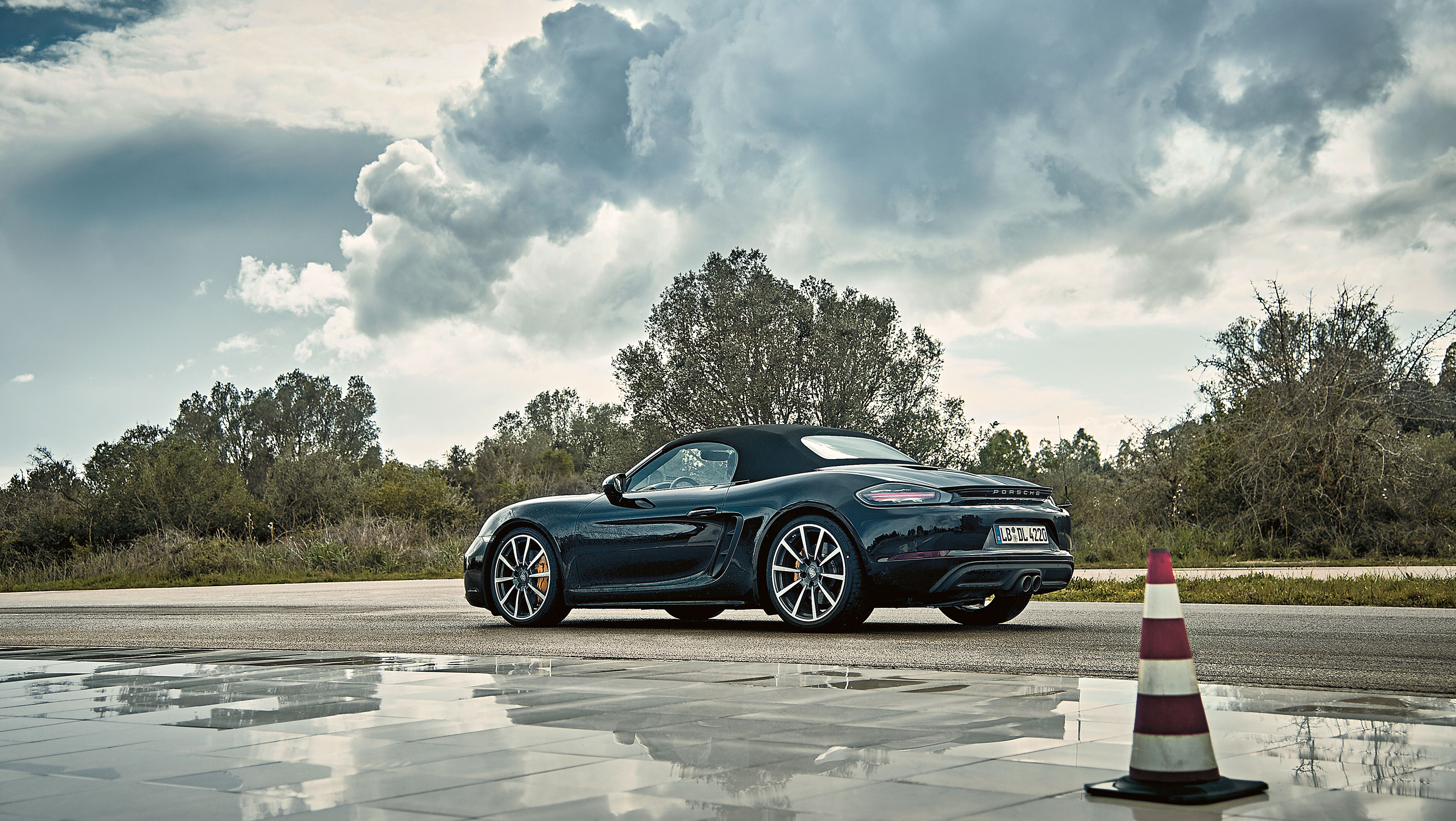 2016 Porsche 718 Boxster parked by a puddle reflecting the sky