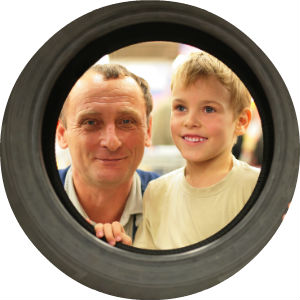 Man and Boy Looking Through the Center of a Tire