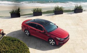 aerial view of red kia optima by beach