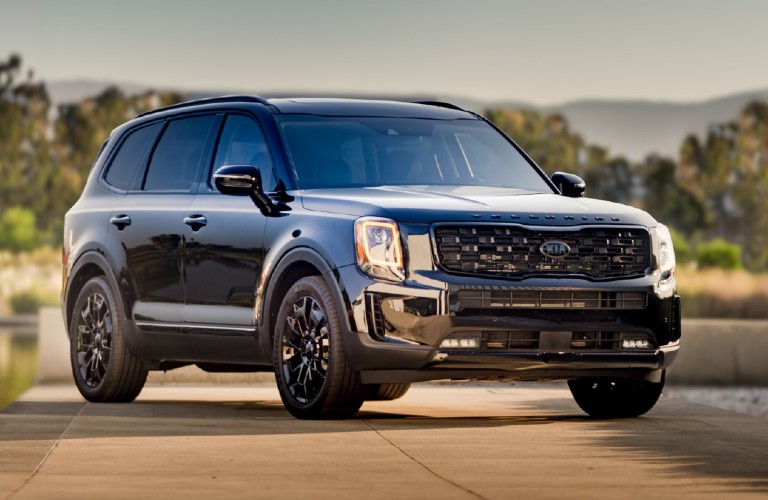 The front and side view of a black 2021 Kia Telluride Nightshade Edition.