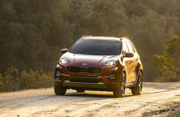 Red 2020 Kia Sportage driving on a dirt road