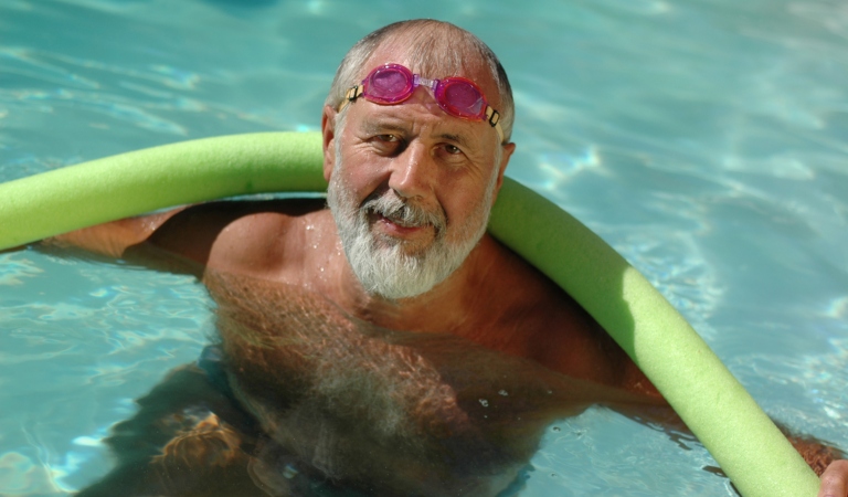 Older gentleman in a pool with a noodle