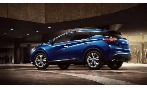2020 Nissan Murano blue facing right showing driver side doors and some of back bumper outside building at night