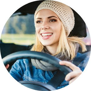 woman in knit hat driving a car while smiling