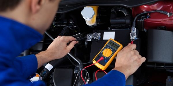 Mechanic testing vehicle battery