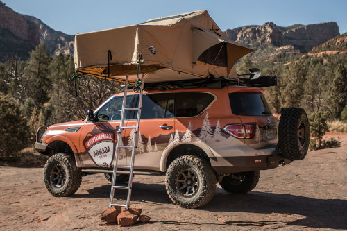 Profile view of Nissan Mountain Patrol vehicle with camper on roof