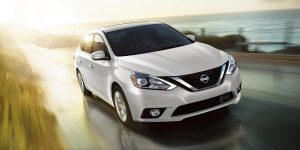 2018 Nissan Sentra driving past a field and water