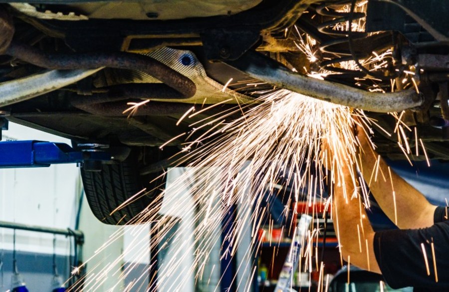 auto mechanic welding under a car
