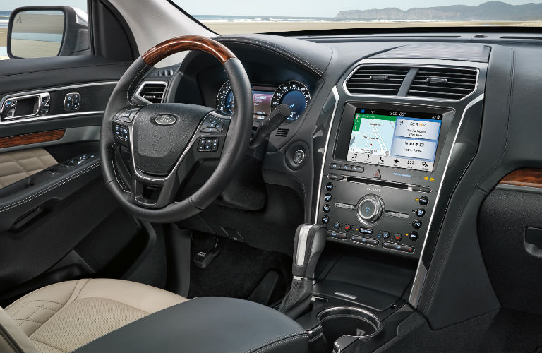 Front row of seating inside 2018 Ford Explorer with steering wheel and center touchscreen prominent