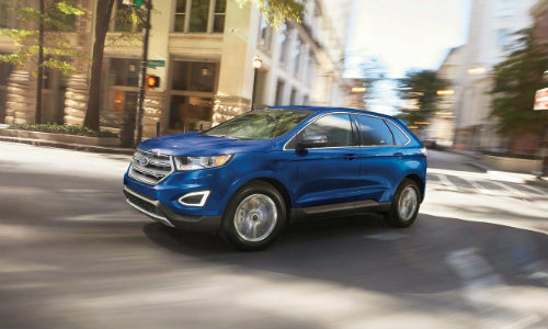 Profile view of blue 2018 Ford Edge turning street corner