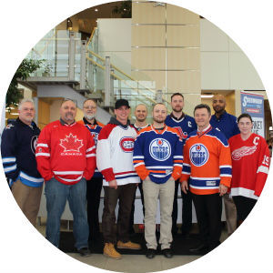 Group of people in hockey jerseys standing and smiling at Sherwood Ford